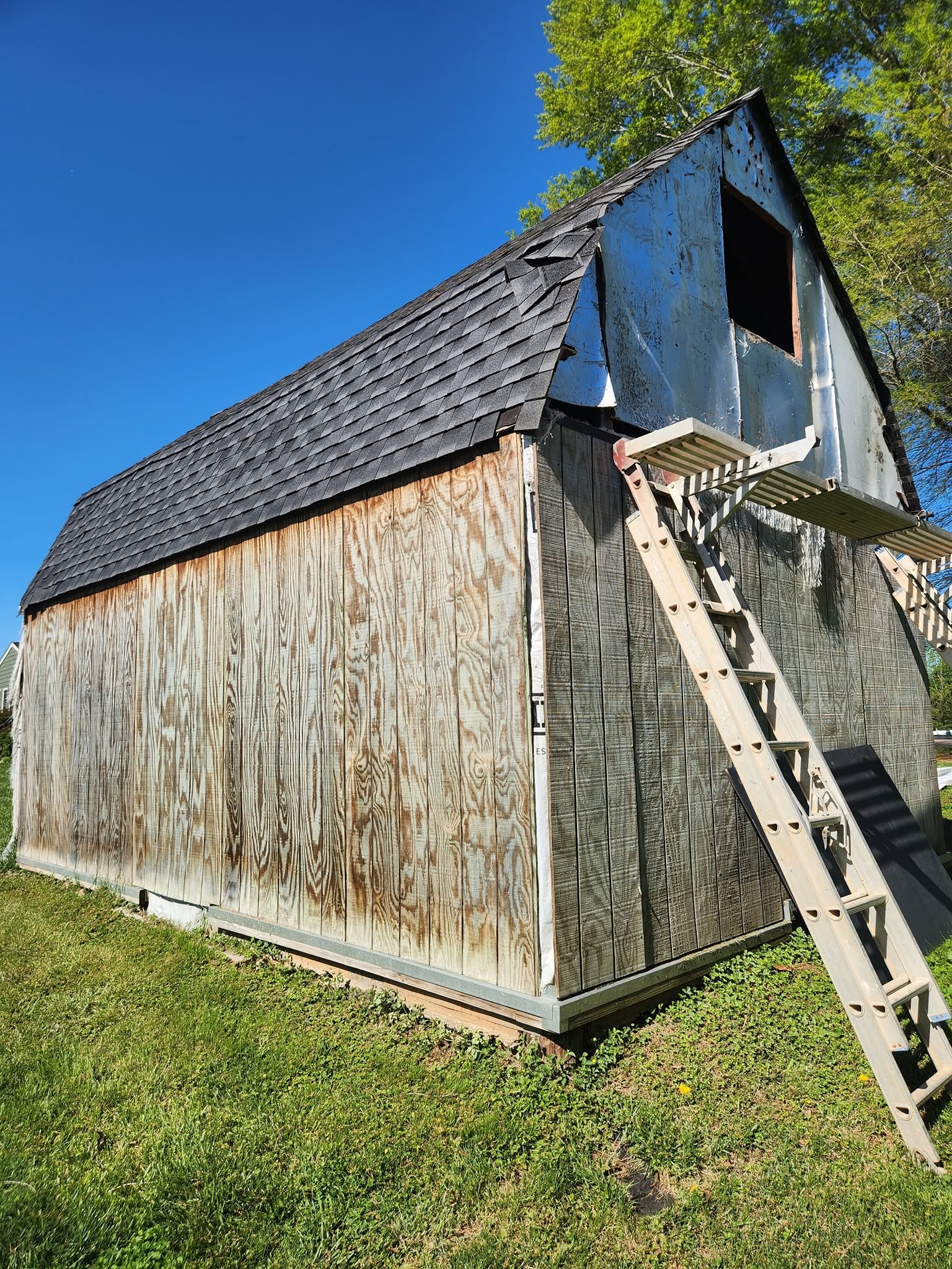 Weathered barn exterior repainted a deep, rich red by 27 Contracting — before